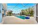 Relaxing enclosed pool area featuring a sparkling pool, ample seating, and lush landscaping at 613 Manns Harbor Dr, Apollo Beach, FL 33572
