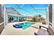 Relaxing enclosed pool area featuring a sparkling pool, ample seating, and views of the home at 613 Manns Harbor Dr, Apollo Beach, FL 33572