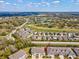 The aerial view captures a townhome community overlooking a golf course, set against a bright blue sky at 6930 Ripple Pond Loop, Zephyrhills, FL 33541