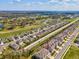 An aerial view showcases a residential community adjacent to a lush golf course and a clear blue sky above at 6930 Ripple Pond Loop, Zephyrhills, FL 33541