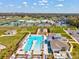 Community aerial view of a large pool, tennis courts, playground, and manicured lawns on a sunny day at 6930 Ripple Pond Loop, Zephyrhills, FL 33541
