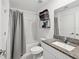 Bathroom featuring a shower with gray curtain and granite-topped vanity and updated fixtures at 6930 Ripple Pond Loop, Zephyrhills, FL 33541