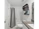 Well-lit bathroom features a shower with gray curtain and granite-topped vanity for a modern touch at 6930 Ripple Pond Loop, Zephyrhills, FL 33541