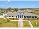 The community center has an expansive facade, set in a well-manicured landscape with a central walkway and ample green space at 6930 Ripple Pond Loop, Zephyrhills, FL 33541