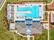 An aerial view reveals a pristine community pool area with lounge chairs, surrounded by lush landscaping at 6930 Ripple Pond Loop, Zephyrhills, FL 33541