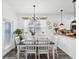 Bright dining area with modern chandelier and views into the kitchen at 6930 Ripple Pond Loop, Zephyrhills, FL 33541