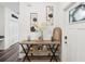 Charming entryway with stylish console table, decorative wall art, and wood look flooring welcomes you to the home at 6930 Ripple Pond Loop, Zephyrhills, FL 33541