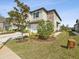 The exterior view shows manicured lawn space with garden and tree that complement the building's design at 6930 Ripple Pond Loop, Zephyrhills, FL 33541