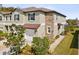 Two-story home features stone accents, neutral color palette, well maintained landscaping, and attached one car garage at 6930 Ripple Pond Loop, Zephyrhills, FL 33541