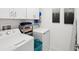 Bright laundry room with modern washer and dryer, overhead cabinets, and storage at 6930 Ripple Pond Loop, Zephyrhills, FL 33541