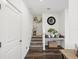 Entryway staircase featuring wood-look flooring, carpeted stairs, decorative accents, and convenient wall mounted table at 6930 Ripple Pond Loop, Zephyrhills, FL 33541