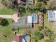 Aerial view of a home with a screened-in pool and a well-manicured lawn, surrounded by mature trees at 8518 Delaware Dr, Weeki Wachee, FL 34607