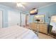 Light and airy bedroom with pale blue walls and a large dresser with decorations, plus TV at 8518 Delaware Dr, Weeki Wachee, FL 34607