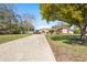 Long driveway leading to a charming home with a well-manicured lawn and mature trees, providing a welcoming entrance at 8518 Delaware Dr, Weeki Wachee, FL 34607
