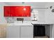 Bright laundry room with red cabinets, a utility sink, modern appliances, and a folding station at 8518 Delaware Dr, Weeki Wachee, FL 34607
