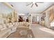 Open-concept living room features plush seating, a decorative mural, and seamless flow into adjacent dining and foyer areas at 8518 Delaware Dr, Weeki Wachee, FL 34607