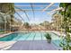 Screened-in pool area with a spacious patio, waterfall feature, and lush landscaping at 8518 Delaware Dr, Weeki Wachee, FL 34607