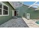 Backyard showcasing a tiled patio area with access to the pool and green siding at 8759 Orient Ne Way, St Petersburg, FL 33702