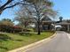 Gated community entrance with lush landscaping and mature trees at 8906 Iron Oak Ave, Tampa, FL 33647