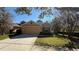 Inviting home with a well-kept lawn and a two-car garage, enhanced by mature trees at 8906 Iron Oak Ave, Tampa, FL 33647