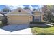 Charming home featuring a two-car garage and a well-maintained front yard with lush landscaping at 8906 Iron Oak Ave, Tampa, FL 33647