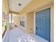 Inviting front porch features a blue door and offers a glimpse of the outdoor surroundings at 8906 Iron Oak Ave, Tampa, FL 33647