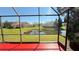 Relaxing view from the screened-in lanai overlooking a tranquil pond and well-maintained green space at 8906 Iron Oak Ave, Tampa, FL 33647