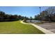 Community tennis court surrounded by lush landscaping and adjacent parking at 8906 Iron Oak Ave, Tampa, FL 33647