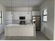Modern kitchen with white cabinets, marble countertops, stainless steel appliances, and an island at 9 Tee View Rd, Rotonda West, FL 33947