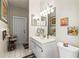 Well-lit bathroom featuring a vanity with double mirrors, a toilet, and neutral tile flooring at 9408 Bluebird Dr, Tampa, FL 33647