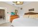 Cozy bedroom with a ceiling fan, a dresser with a TV, and a comfortable bed with decorative pillows at 9408 Bluebird Dr, Tampa, FL 33647