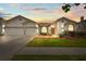 Charming single-story home featuring a well-manicured lawn and a two-car garage, illuminated by a colorful sunset at 9408 Bluebird Dr, Tampa, FL 33647