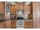 A fully equipped kitchen features stainless steel appliances, wooden cabinets, and stylish backsplash, creating a cozy vibe at 9408 Bluebird Dr, Tampa, FL 33647