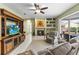 A relaxing living room features a ceiling fan, fireplace, and a sliding door to the pool at 9408 Bluebird Dr, Tampa, FL 33647