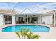 Refreshing swimming pool surrounded by a screened enclosure, perfect for outdoor relaxation and entertainment at 9408 Bluebird Dr, Tampa, FL 33647