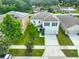 Stunning aerial view of home with well-kept lawn, complemented by mature trees in a serene neighborhood at 9937 Warm Stone St, Thonotosassa, FL 33592