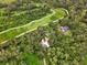 Aerial view of a charming home with pool surrounded by lush landscaping and mature trees at 1001 Crocker Ln, Plant City, FL 33565