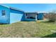 Wide backyard featuring a screened porch, lush grass, and blue exterior at 10206 Wexford Ct, Tampa, FL 33615