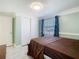 Cozy bedroom featuring a window with curtains and ample storage space with a sliding door closet at 10206 Wexford Ct, Tampa, FL 33615