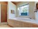 Bathroom with a large soaking tub, a shower, and a view of an exterior window at 1034 Marco Ne Dr, St Petersburg, FL 33702