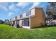 Exterior view of townhomes showing lawn, screened lanai, and central AC unit at 1154 Kennewick Ct, Wesley Chapel, FL 33543