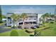 Aerial view of a multi-story condo building, palm trees, parking area, and green lawns at 12055 3Rd E St # 103, Treasure Island, FL 33706