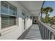Exterior of a white condo building with a balcony, windows, and palm tree at 12055 3Rd E St # 103, Treasure Island, FL 33706