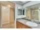 A primary bathroom features a vanity with a sink and a large mirror plus a walk-in shower at 12055 3Rd E St # 103, Treasure Island, FL 33706