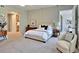 This bright bedroom features a chair, modern furniture, and a view to the hall and en-suite bathroom at 12055 3Rd E St # 103, Treasure Island, FL 33706