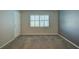 This bedroom features neutral carpeting, a window with white shutters, and a gray accent wall at 12055 3Rd E St # 103, Treasure Island, FL 33706