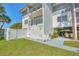 White condo building with green lawn, patio, and palm tree on a bright day at 12055 3Rd E St # 103, Treasure Island, FL 33706