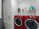 Laundry room featuring red washer and dryer and built in shelving at 12310 Juniper Field Ct, Riverview, FL 33579