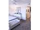 Bright main bedroom with a white dresser, tufted bench, and view to the ensuite bathroom at 12760 Indian Rocks Rd # 1066, Largo, FL 33774