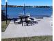 Lakeside picnic spot with table, benches, umbrella, and chairs on a concrete slab at 12760 Indian Rocks Rd # 1066, Largo, FL 33774